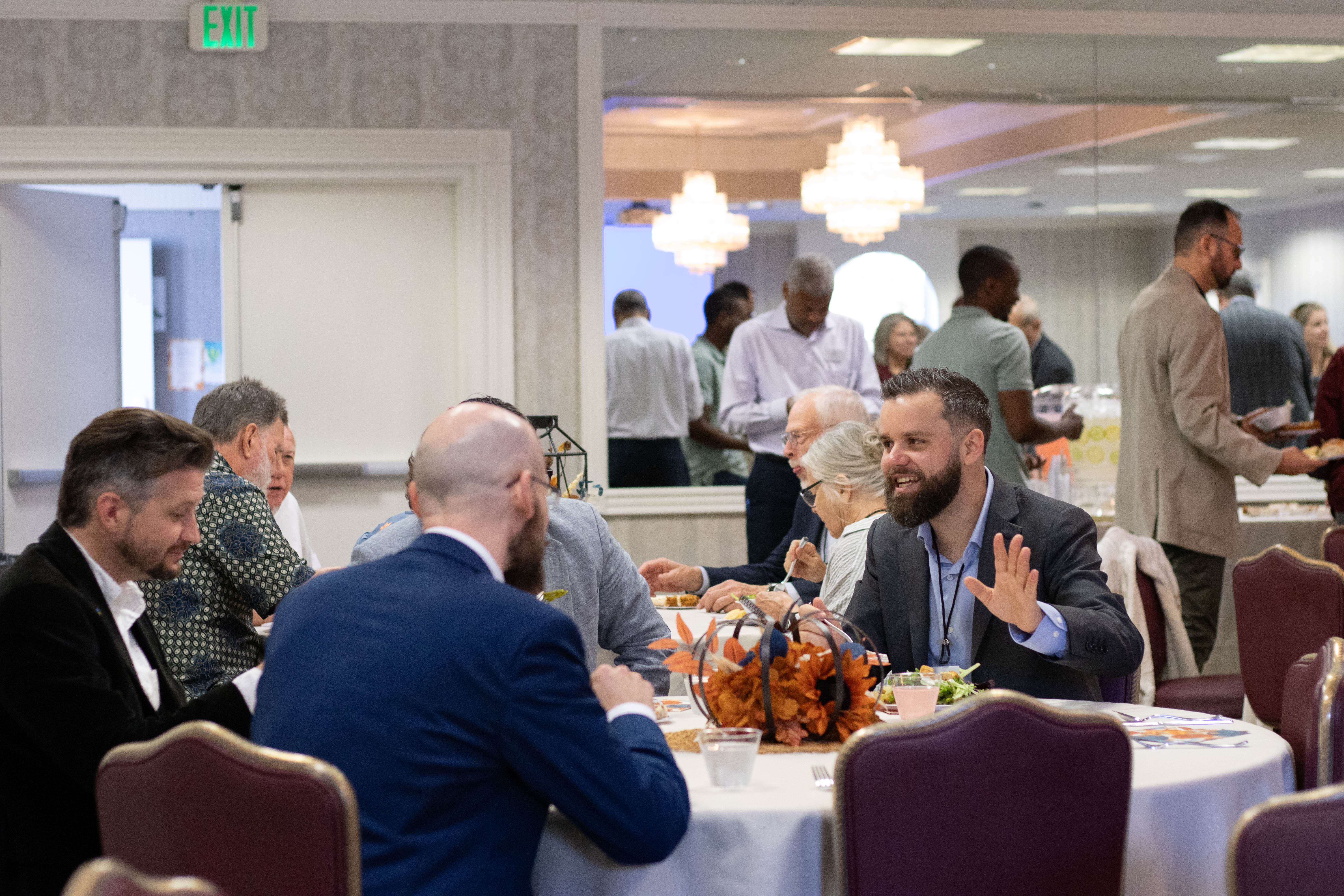 three people smiling, holding an award
