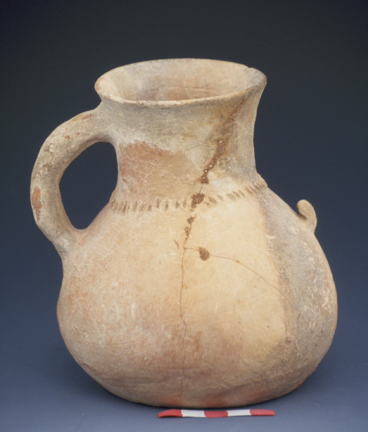 a lopsided tan pitcher