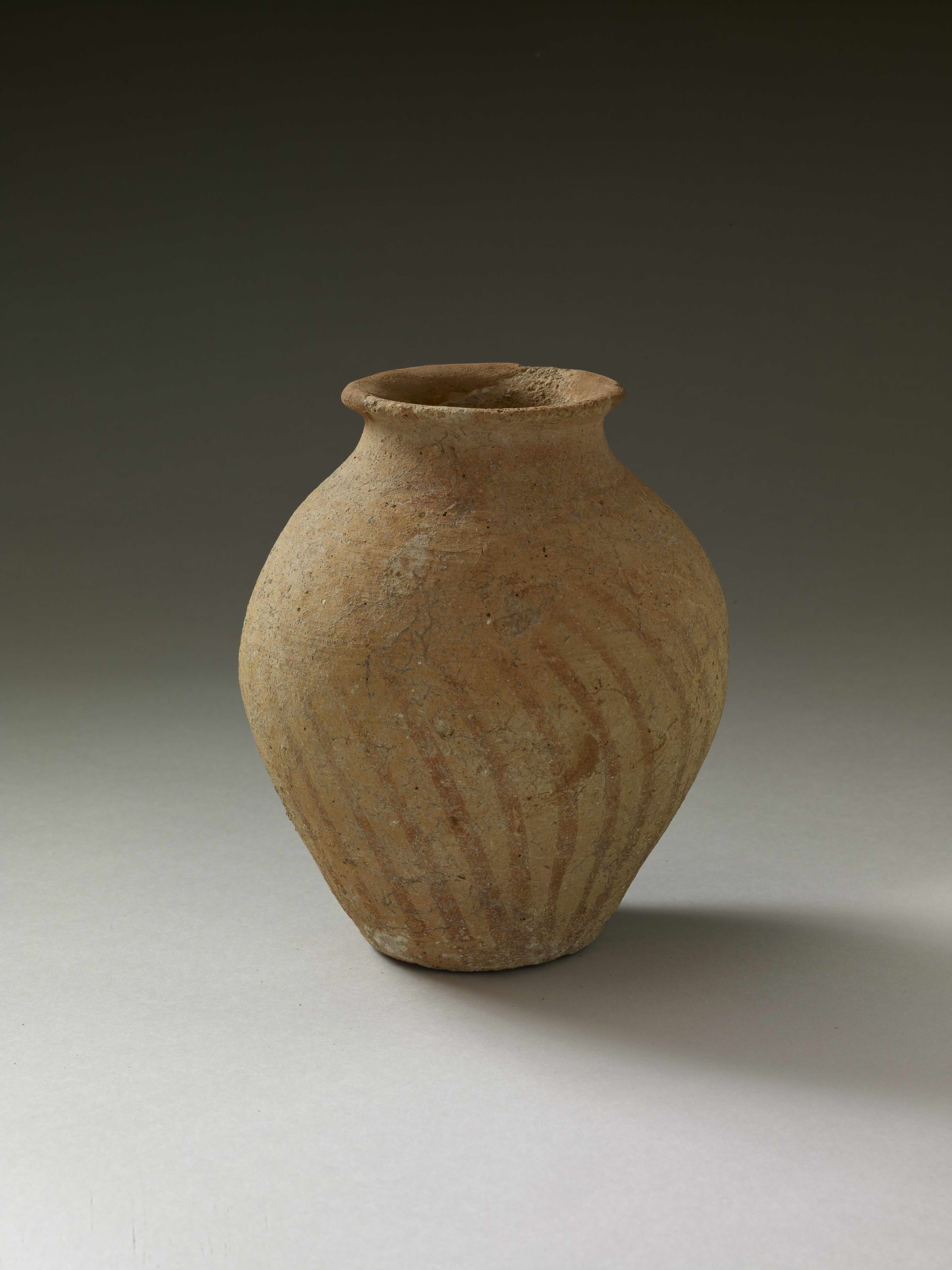 an orange jar with line pattern