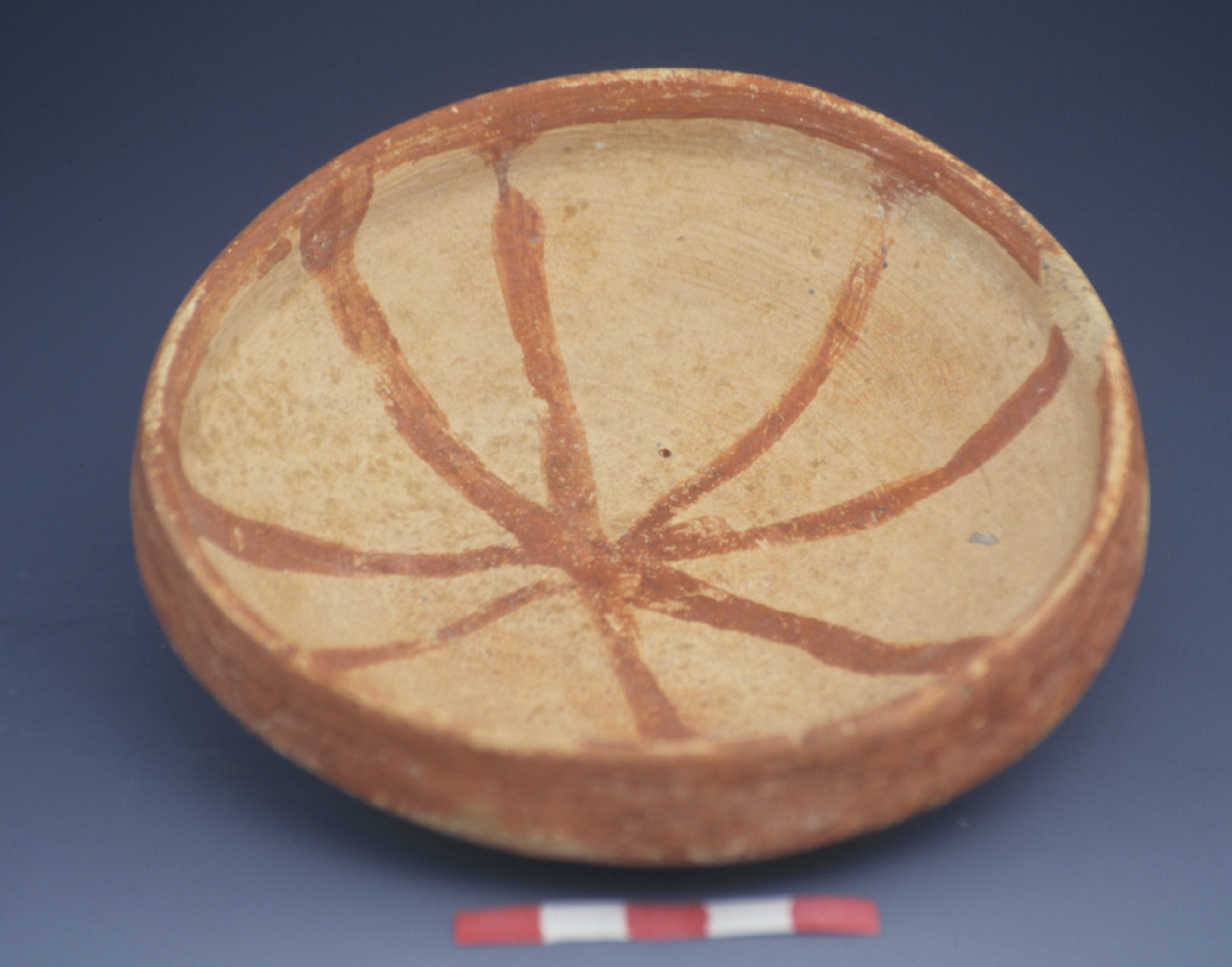 an orange bowl with a line pattern that converges at the center