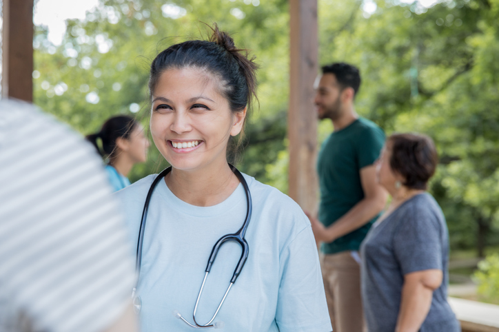 Medical worker listening to a child's heart through a stethoscope in a remote location.