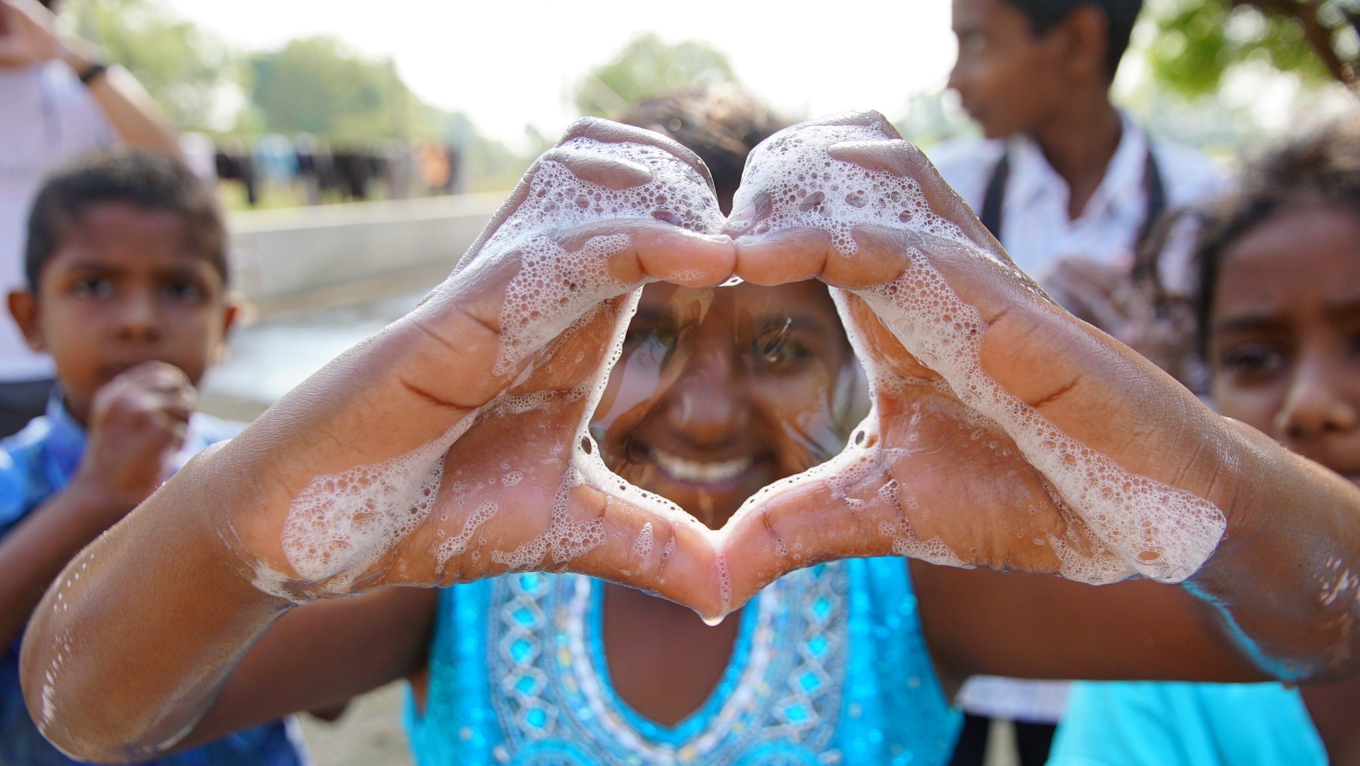 Girl making a heart with bubbles