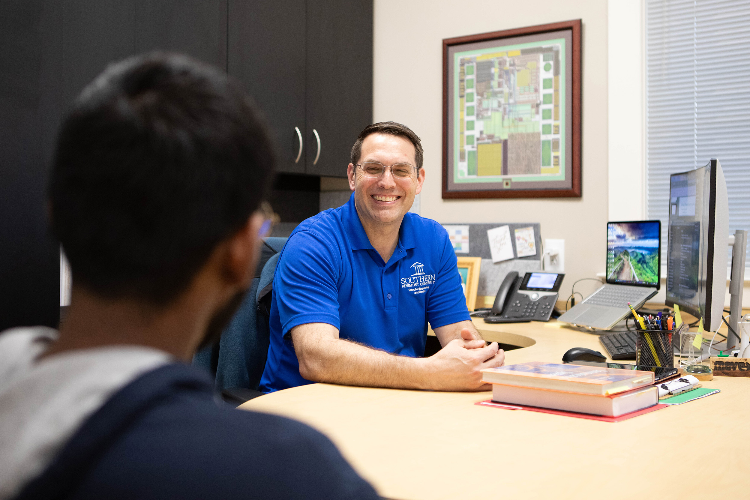 a professor speaking with a student in his office